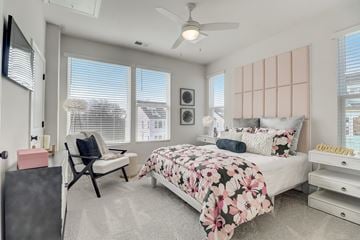 Charlotte townhouse for rent - A bedroom with a large bed and a ceiling fan.