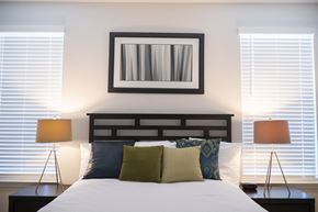 Hickory townhouse for rent - a bedroom with two windows with white blinds and a bed with white pillows and green at Landon Green Artisan Cottages Apartments, Hickory, NC