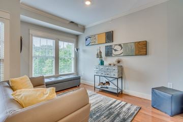 Charlotte apartment for rent - A living room with a grey couch and a yellow pillow.