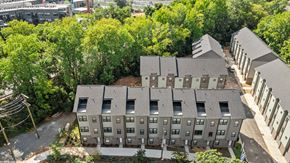 Charlotte townhouse for rent - A large grey building surrounded by trees.