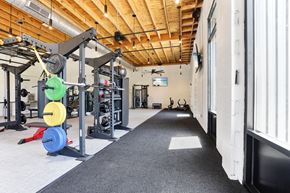 Spartanburg apartment for rent - A gym with a variety of equipment including a weight rack and a bench.