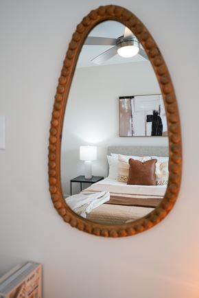 Concord apartment for rent - A bedroom with a round mirror on the wall.