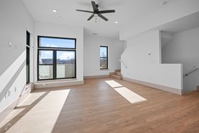 Charlotte townhouse for rent - A spacious room with a ceiling fan and large windows.