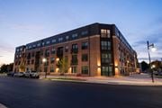 Rock Hill apartment for rent - a large brick building on a street corner at dusk