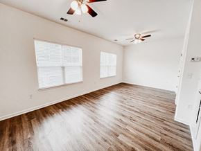 Charlotte apartment for rent - an empty living room with wood floors and a ceiling fan