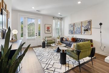 Charlotte townhouse for rent - A living room with a black and white rug and a green chair.