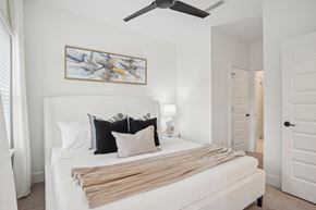 Charlotte apartment for rent - A bedroom with a bed, pillows, and a painting on the wall.
