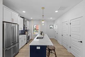 Charlotte townhouse for rent - A modern kitchen with white cabinets and a blue island.