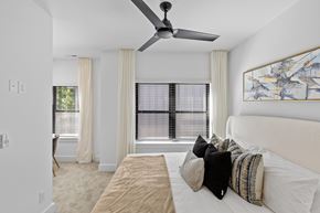 Charlotte townhouse for rent - A bedroom with a large bed and a ceiling fan.