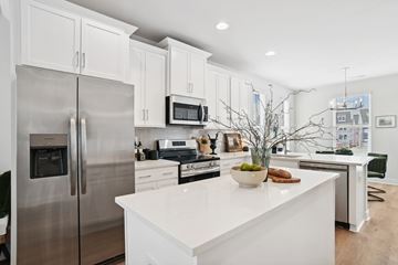Charlotte townhouse for rent - A modern kitchen with a stainless steel refrigerator and white cabinets.