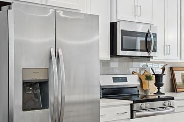 Charlotte townhouse for rent - A modern kitchen with a stainless steel refrigerator and a black microwave above the stove.