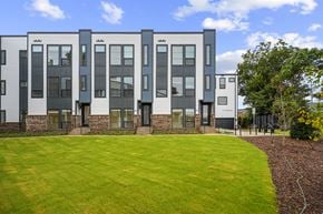 Charlotte townhouse for rent - A modern building with grey and white exterior and a green lawn in front.
