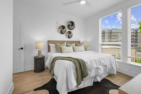 Charlotte townhouse for rent - A bedroom with a large bed and a window with blinds.