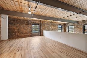 Lenoir apartment for rent - an empty room with exposed brick and wood floors and a white wall