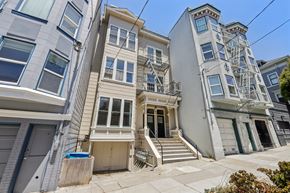 San Francisco apartment for rent - A row of three-story houses with white and grey facades and blue doors.
