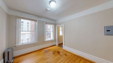 San Francisco apartment for rent - A room with wooden floors and a window overlooking a building.