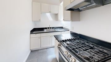 San Francisco apartment for rent - A kitchen with a black stove top oven and white cabinets.