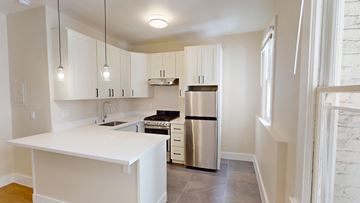 San Francisco apartment for rent - A kitchen with white cabinets and a stainless steel refrigerator.