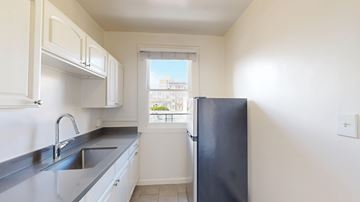 San Francisco apartment for rent - A kitchen with white cabinets and a black refrigerator.