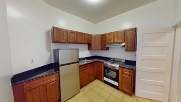 San Francisco apartment for rent - A kitchen with wooden cabinets and black countertops.