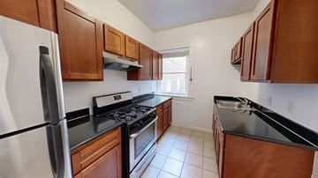 San Francisco apartment for rent - A kitchen with wooden cabinets and black countertops.