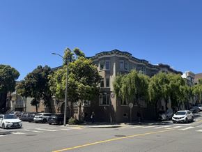 San Francisco apartment for rent - A street view with cars parked on the side and a building with a tree in front of it.