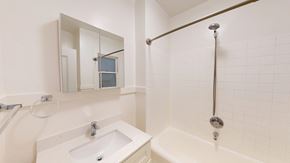 San Francisco apartment for rent - A white bathroom with a sink, mirror, and bathtub.
