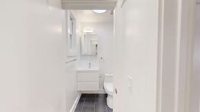 San Francisco apartment for rent - A white bathroom with a toilet, sink, and mirror.
