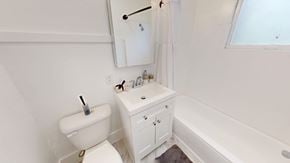San Francisco apartment for rent - A white toilet with a toilet brush on top of it.