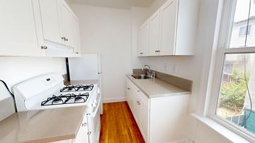 San Francisco apartment for rent - A small kitchen with a white stove and cabinets.