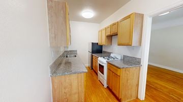 San Francisco apartment for rent - A kitchen with wooden cabinets and a granite countertop.
