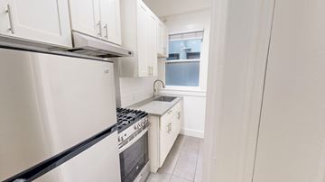 San Francisco apartment for rent - A kitchen with white cabinets and a stainless steel refrigerator.