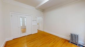 San Francisco apartment for rent - A room with a white wall and a wooden floor with a radiator.