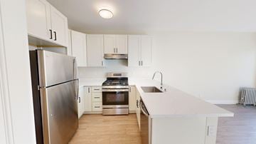 San Francisco apartment for rent - A modern kitchen with white cabinets and stainless steel appliances.
