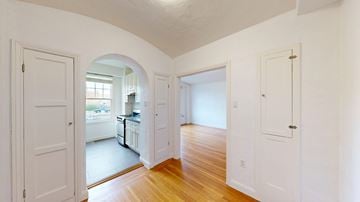 San Francisco apartment for rent - A white interior with a kitchen visible through an archway.