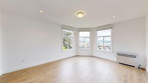 San Francisco apartment for rent - A spacious room with wooden floors and a radiator.