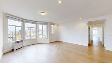 San Francisco apartment for rent - A spacious room with a window overlooking a cityscape.