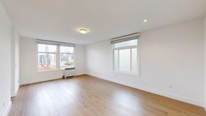 San Francisco apartment for rent - A large empty room with wooden floors and two windows.