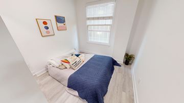San Francisco apartment for rent - A bedroom with a bed covered in a blue blanket and two framed pictures on the wall.