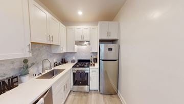 San Francisco apartment for rent - A kitchen with white cabinets and a marble backsplash.