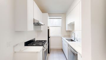 San Francisco apartment for rent - A white kitchen with a black stove top oven.