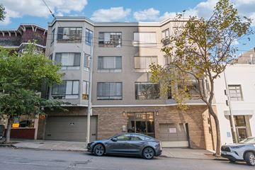 San Francisco apartment for rent - A grey car is parked in front of a building with a garage door.
