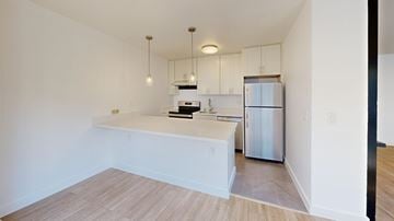 San Francisco apartment for rent - A kitchen with white cabinets and a refrigerator.