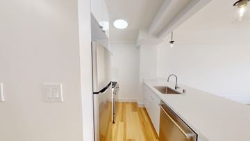 San Francisco apartment for rent - A white kitchen with a sink and a door.