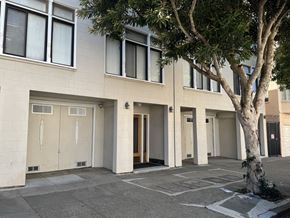 San Francisco apartment for rent - A tree is in front of a building with a white door.