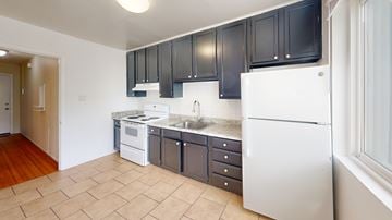 San Francisco apartment for rent - A kitchen with black cabinets and white appliances.