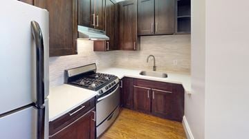San Francisco apartment for rent - A kitchen with a white fridge and a white stove top oven.