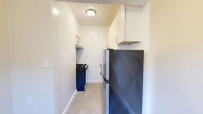San Francisco apartment for rent - A kitchen with a refrigerator, trash can, and cabinets.
