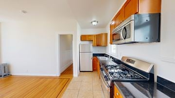 San Francisco apartment for rent - A kitchen with a stove top oven and a microwave above it.