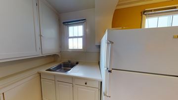 San Francisco apartment for rent - A kitchen with a white refrigerator and cabinets.